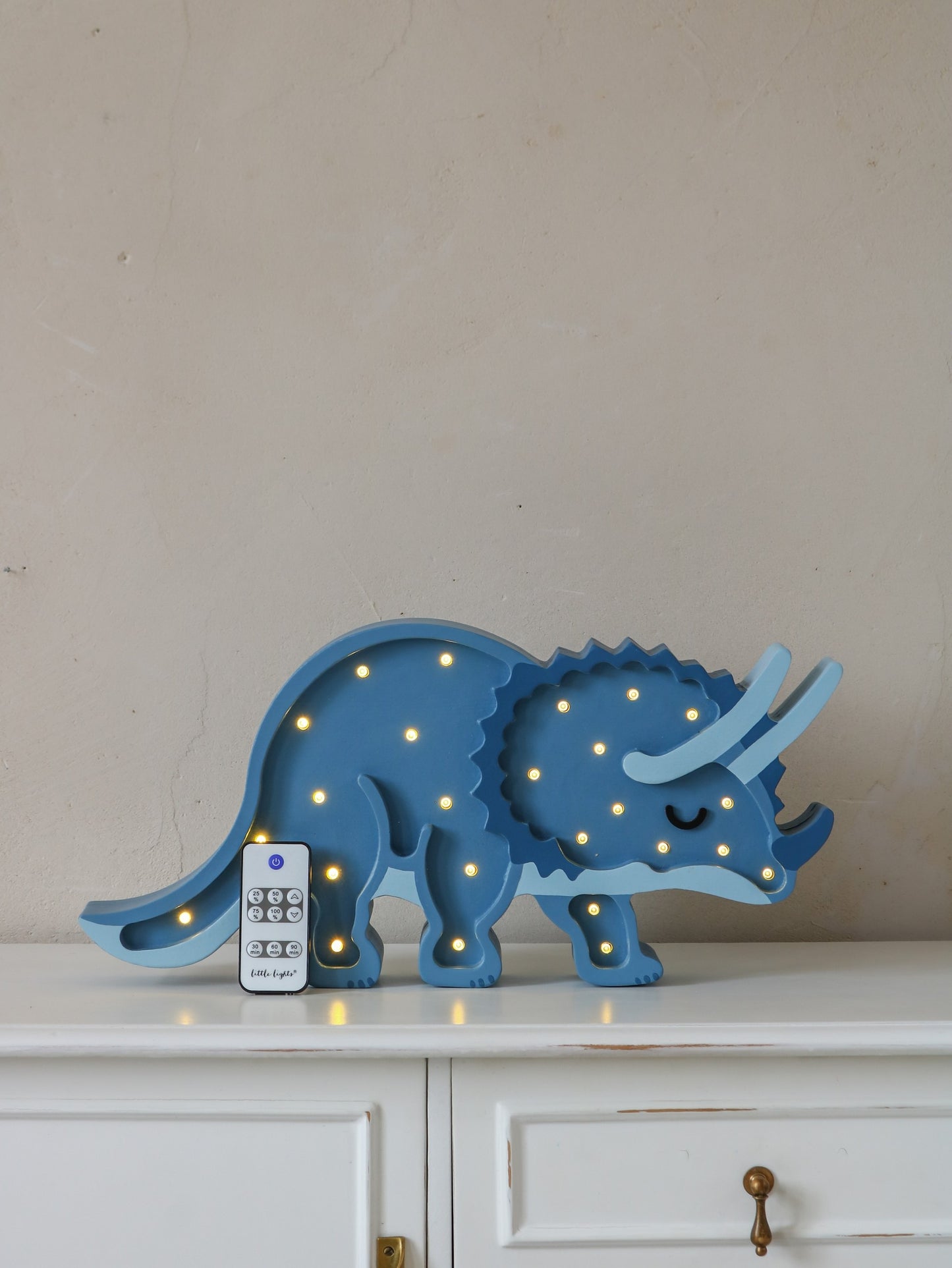 Blue triceratops LED lamp with remote control and dimmer function on display shelf