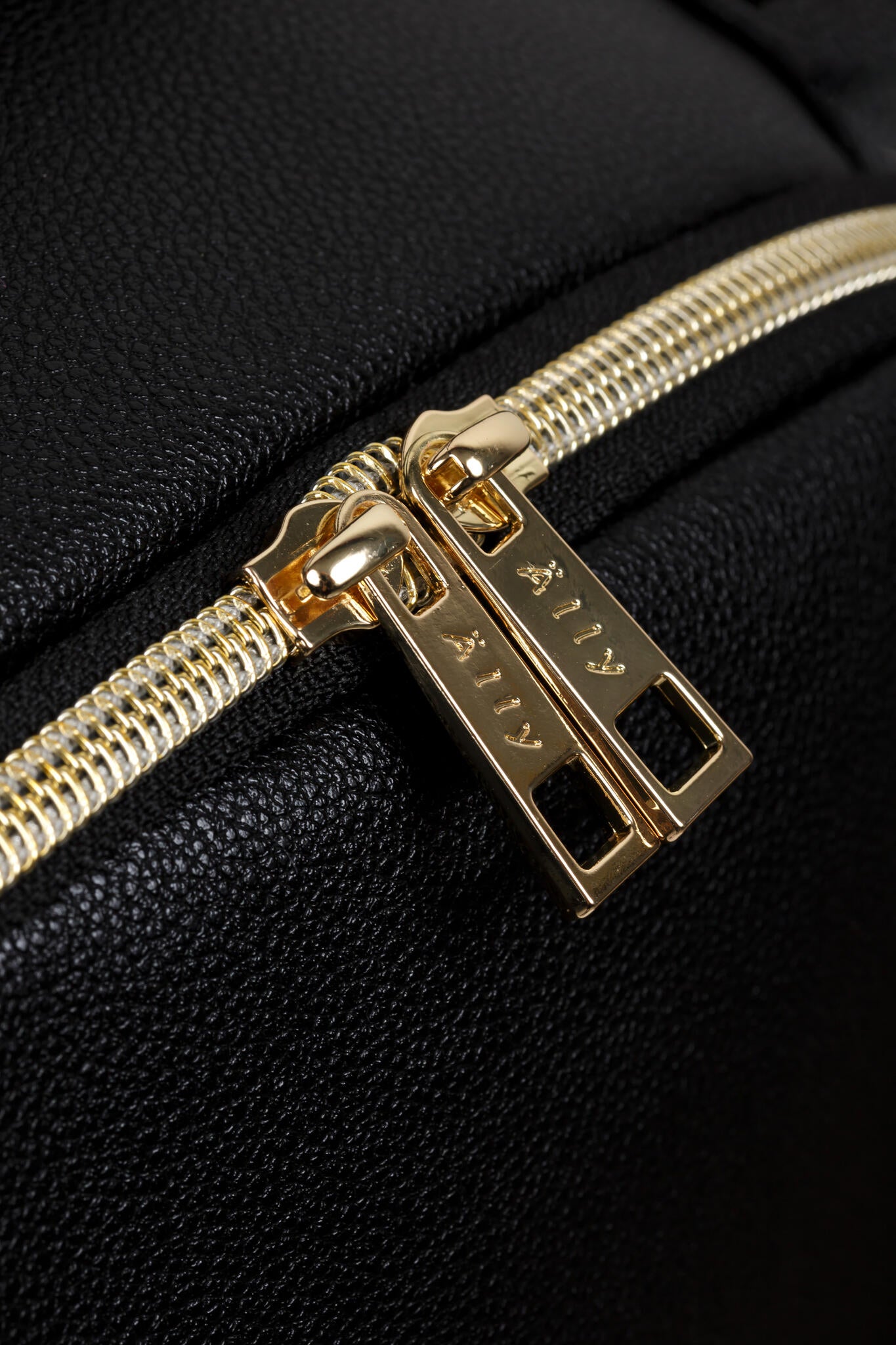 Close-up of gold zipper hardware on black vegan leather diaper backpack