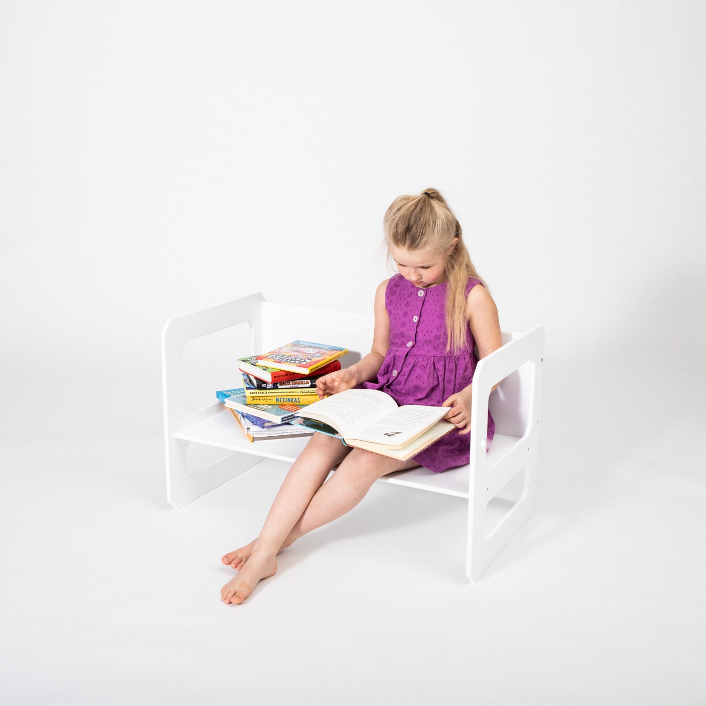 Young girl using white Montessori table for drawing and creative play