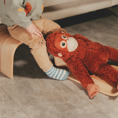 Toddler playing with toy near wooden step stool indoors