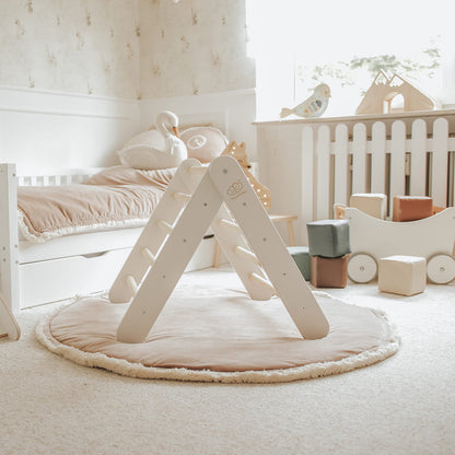 White climbing wall with natural wood ladder indoors in nursery room