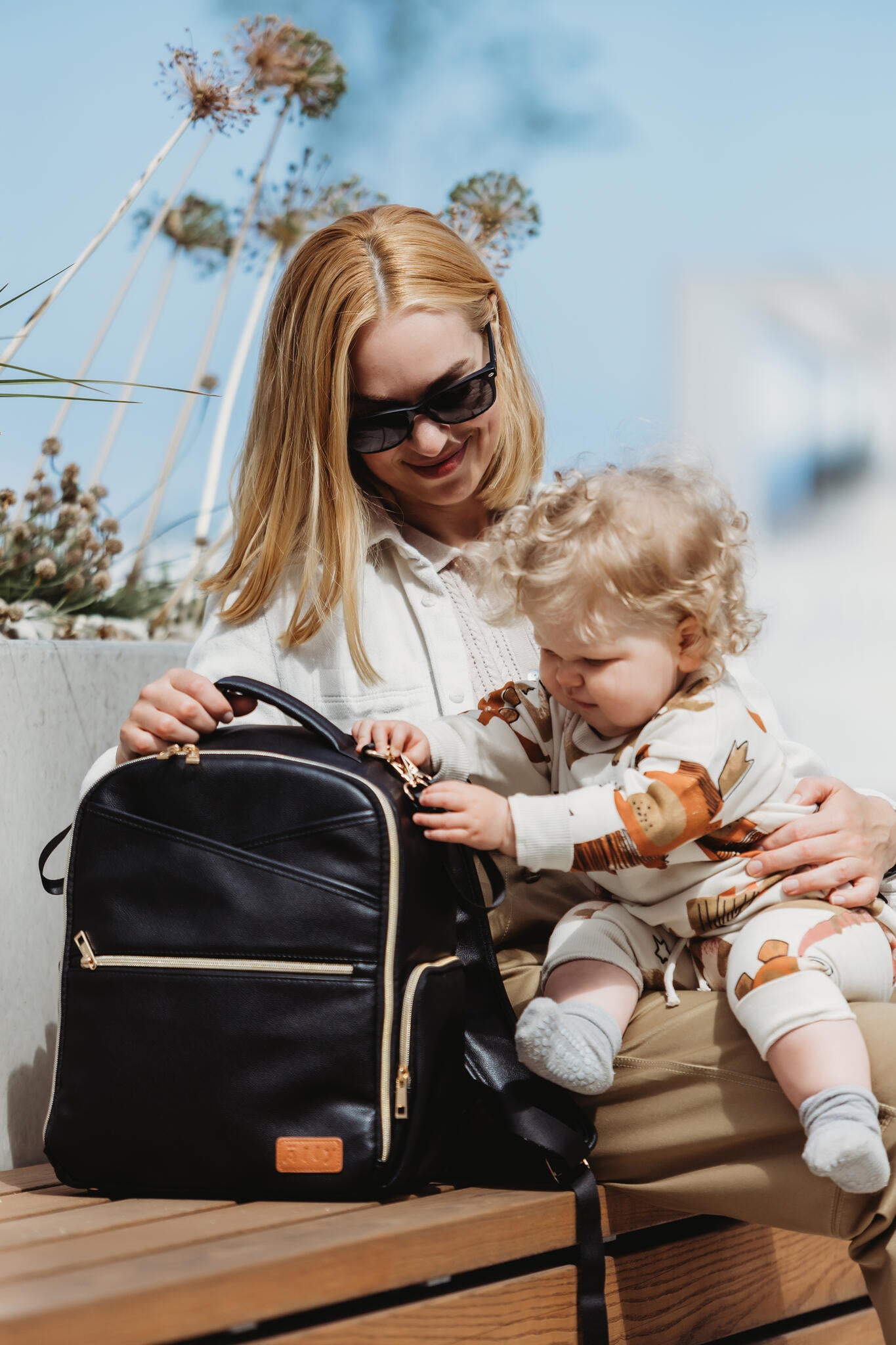 Parent and baby playing with black Ally Scandic diaper backpack