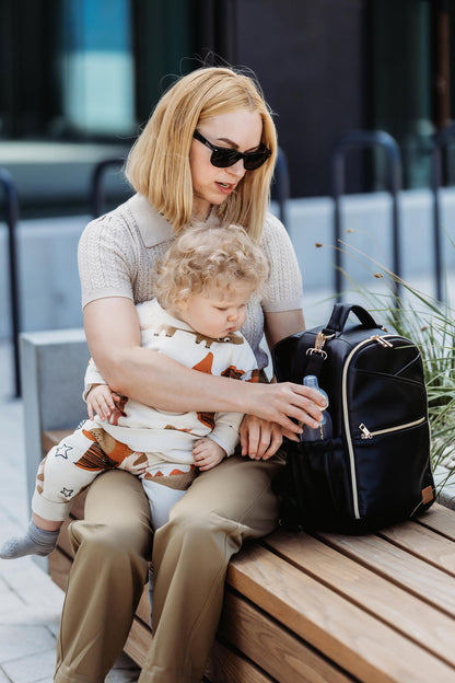 Woman sitting with toddler and black Ally Scandic diaper backpack