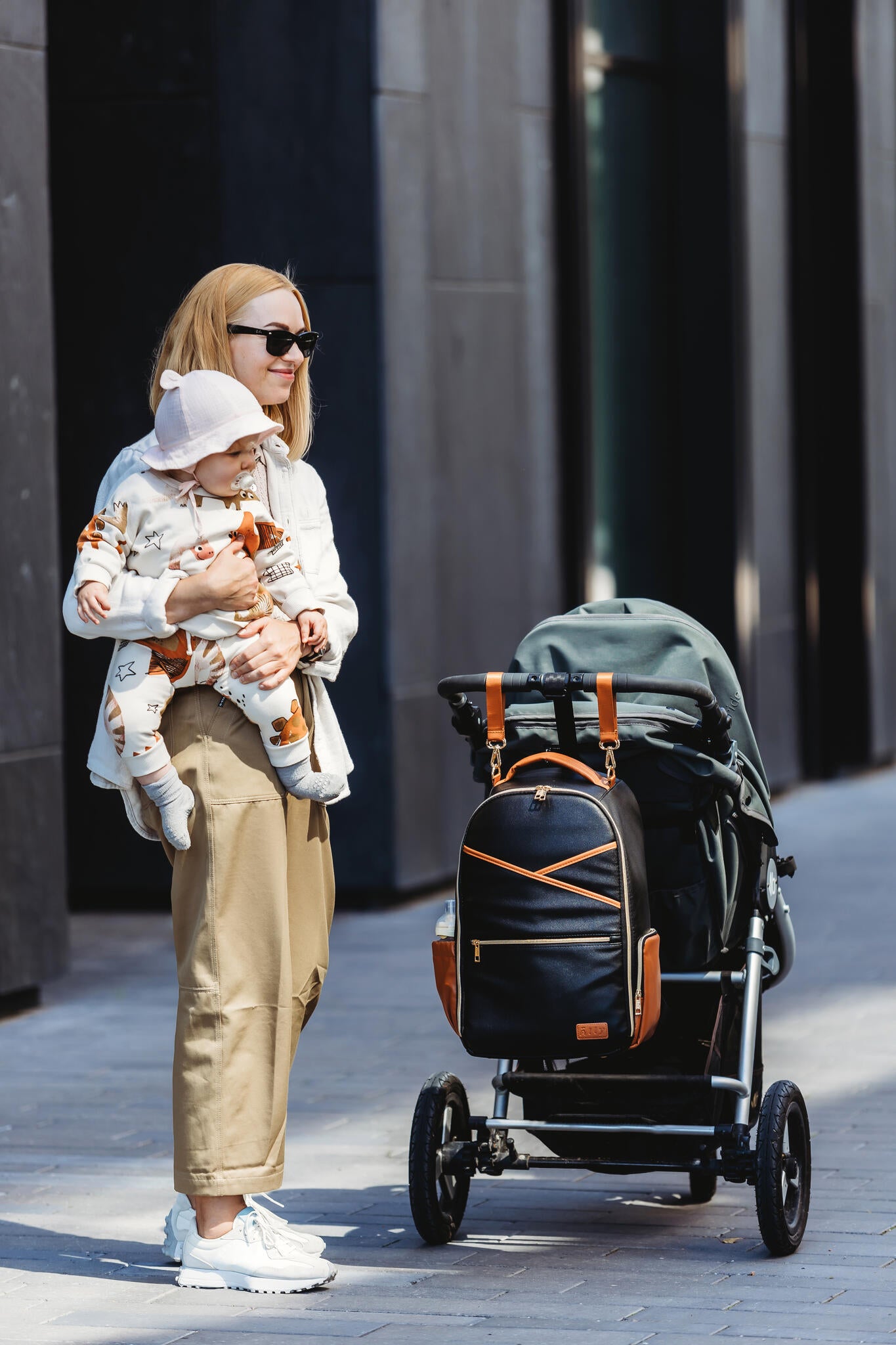 Parent sitting at café table with toddler and black coffee diaper backpack nearby