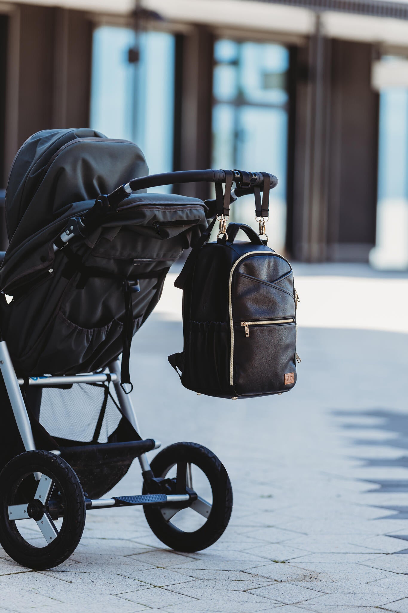 Black Ally Scandic diaper backpack hanging on stroller handle