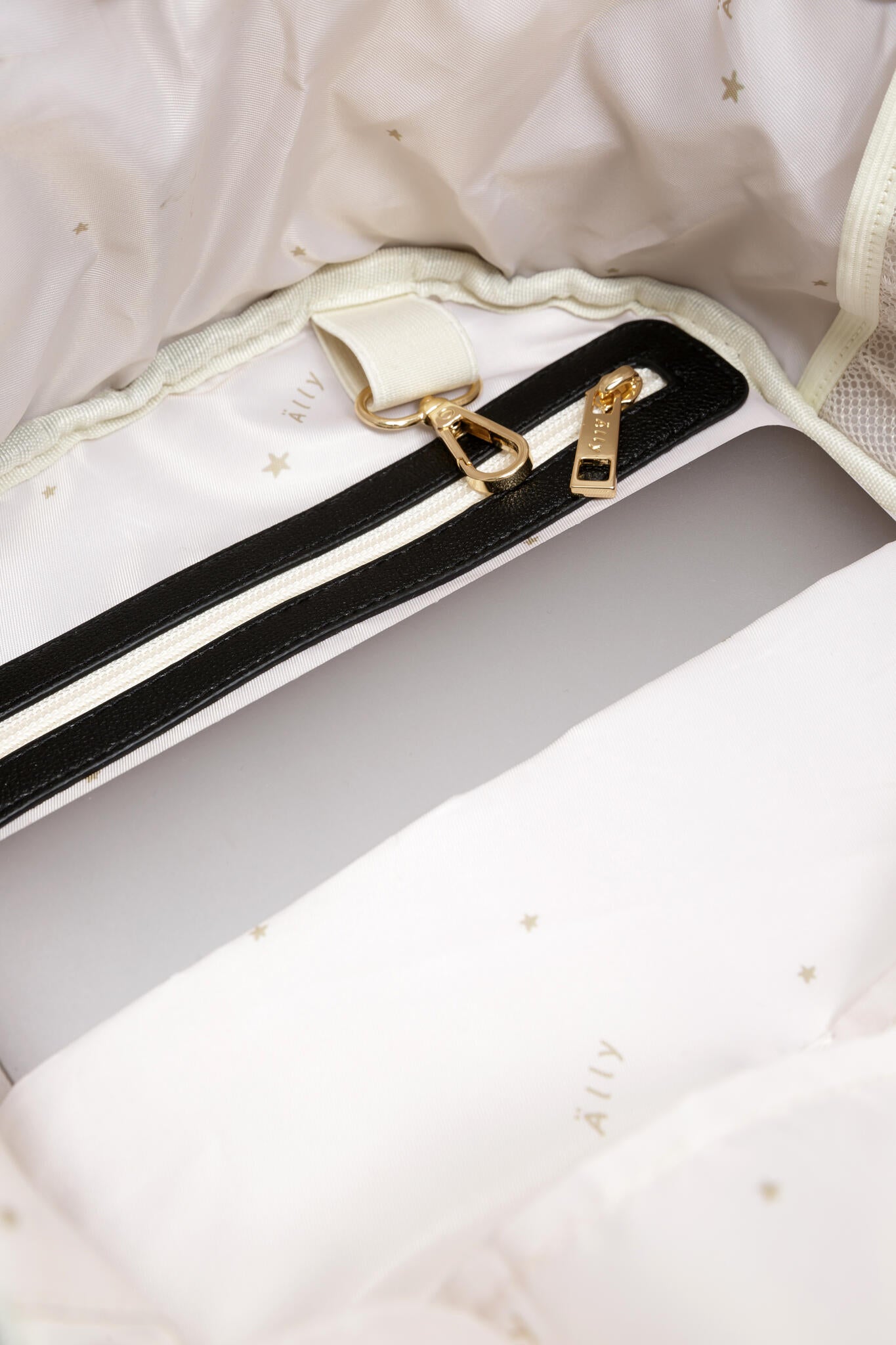 Shoulder straps with gold hardware included in espresso diaper backpack packaging