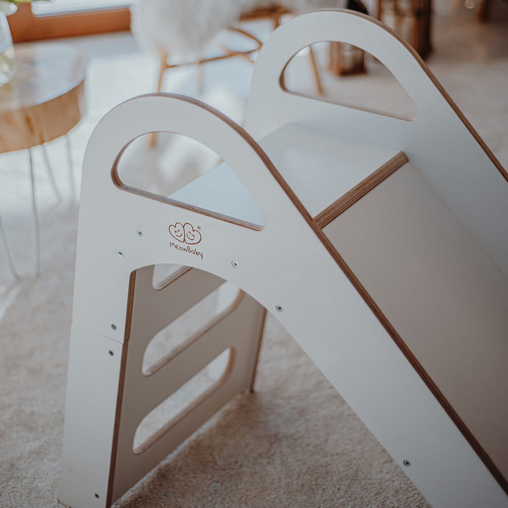 Close-up of white wooden slide's curved climbing ladder with handholds