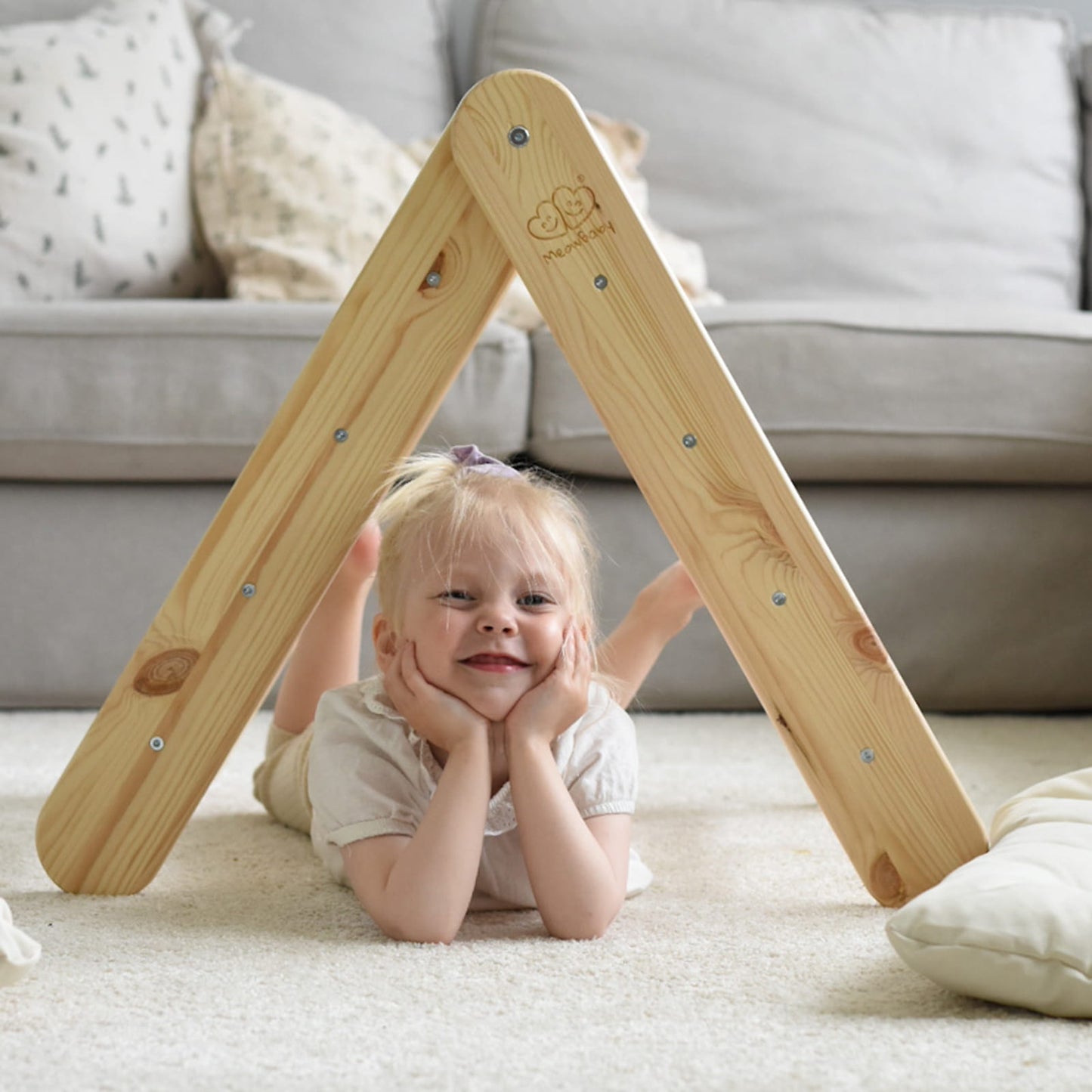 Toddler playing under natural wood ladder tent house indoors