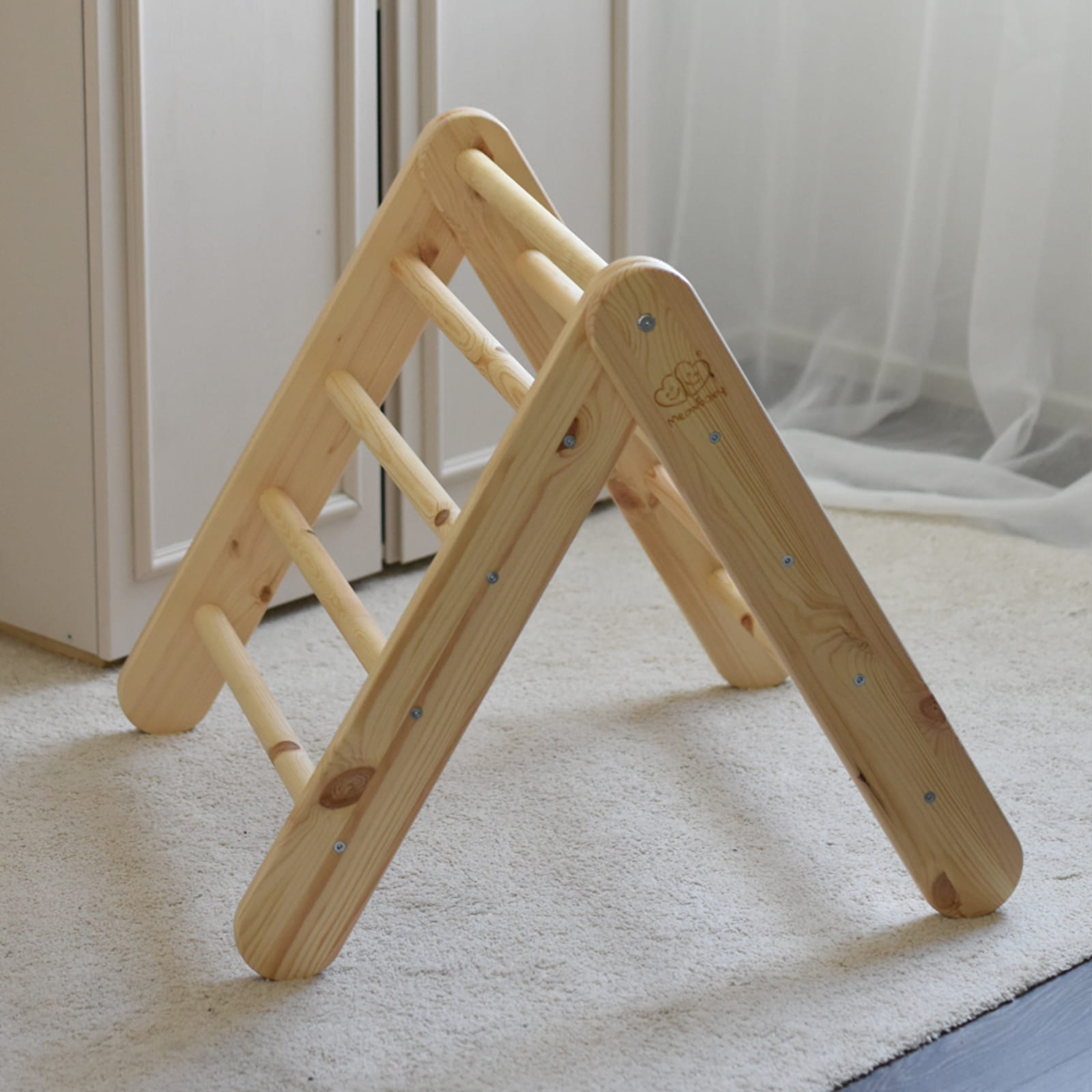 Natural wood climbing ladder alone in room with pink fabric tent attached