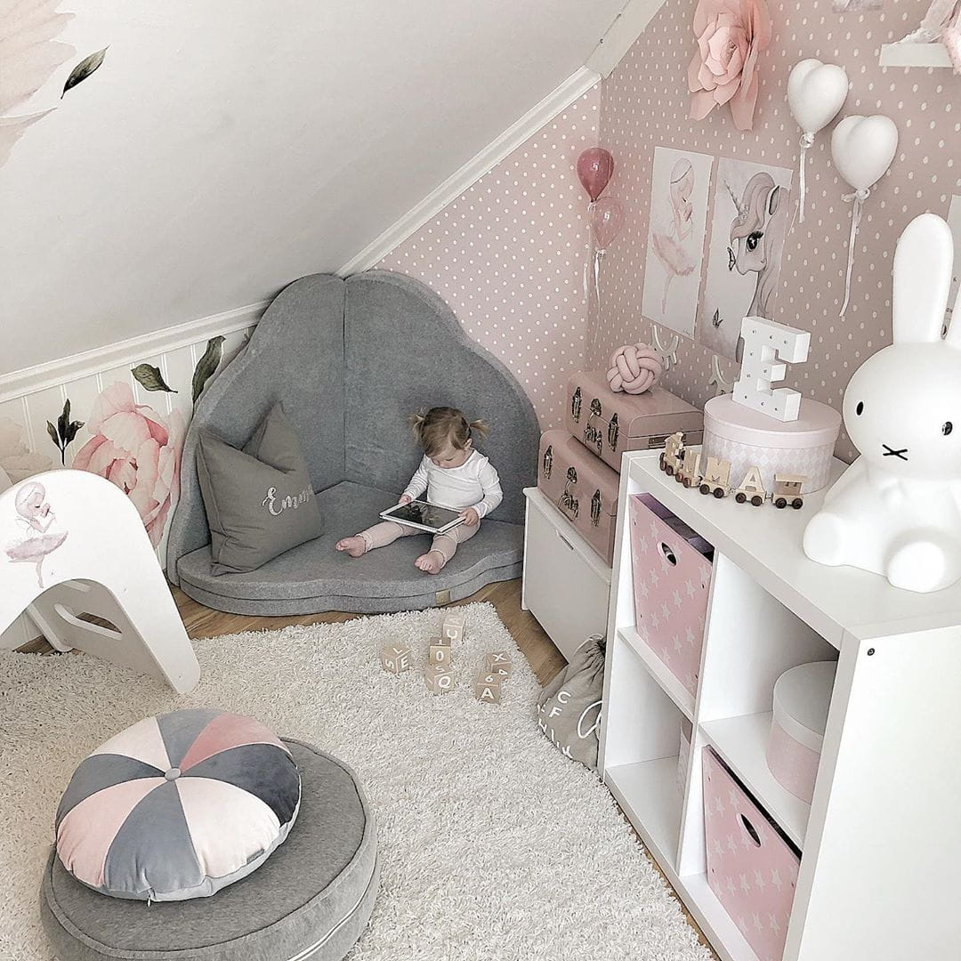 Baby playing inside light grey cloud mat in styled nursery room with accessories
