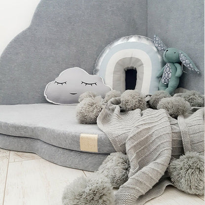 Cloud play mat styled as cozy sleeping nest with toys and blankets for toddler