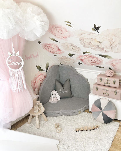 Decorative styled shot of grey velvet cloud mat in pink and white girl's bedroom