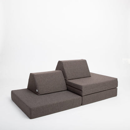 Dark brown modular foam furniture configured as a low sofa with cushions and backrest pieces