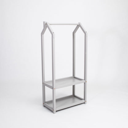 Gray wooden house-shaped clothing rack with two open storage shelves, side angle view