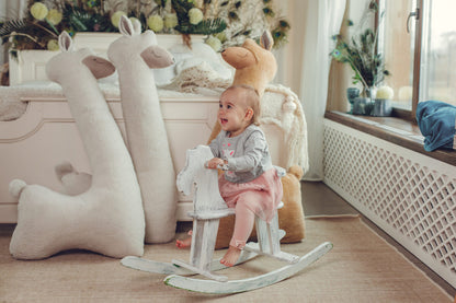 Toddler with giant beige alpaca plush toys – scale reference showing 1m height in playroom
