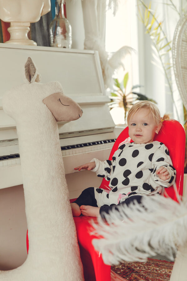 Baby next to giant beige alpaca soft toy Kai aš mažas buvau – showing size and cuddly appeal
