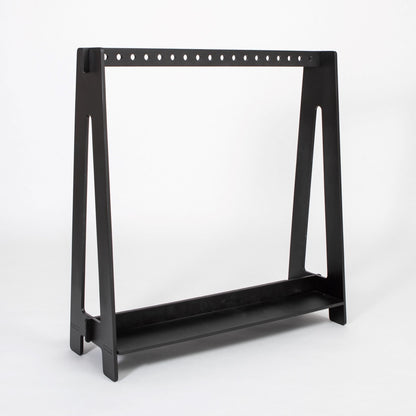 Black Montessori clothing rack with perforated rod and bottom shelf, side view