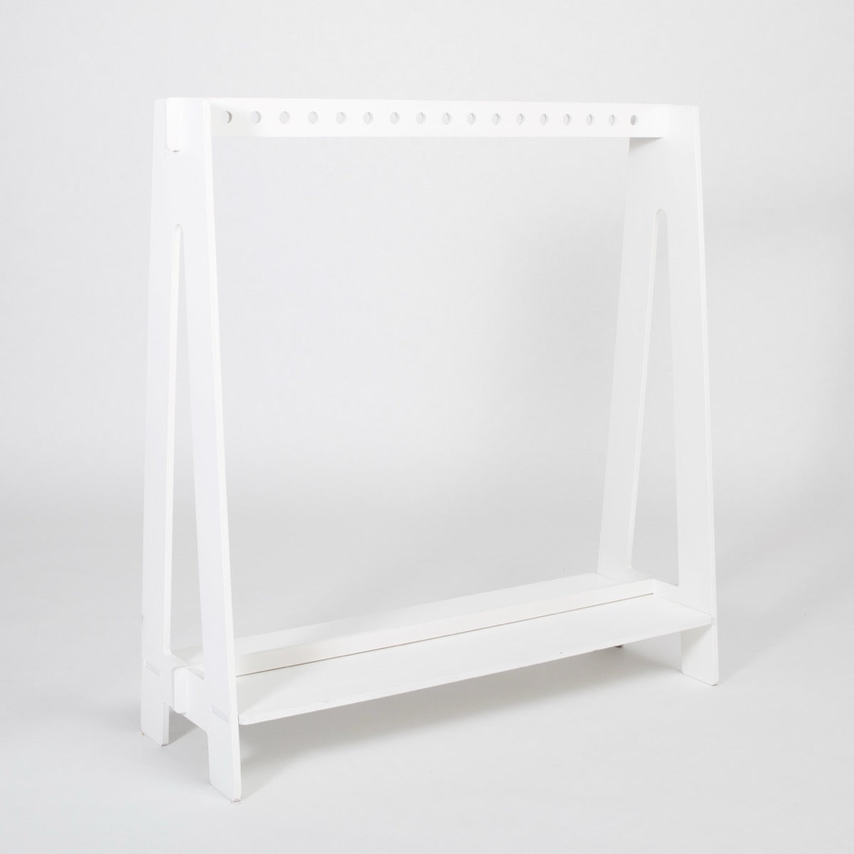 White wooden children's clothing rack with bottom shelf for shoes and storage
