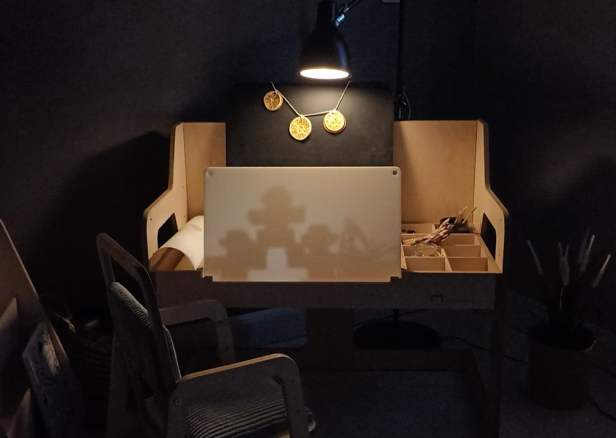 Top-down view of Montessori table with white writing surface and built-in storage compartments