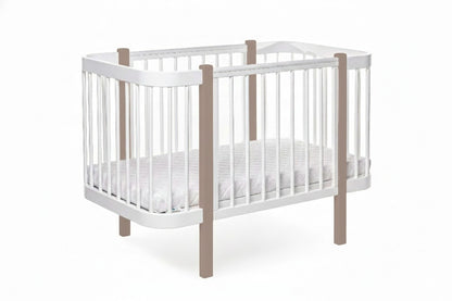 Front view of KOTTO ELIN crib showing white frame and natural wood posts with mattress