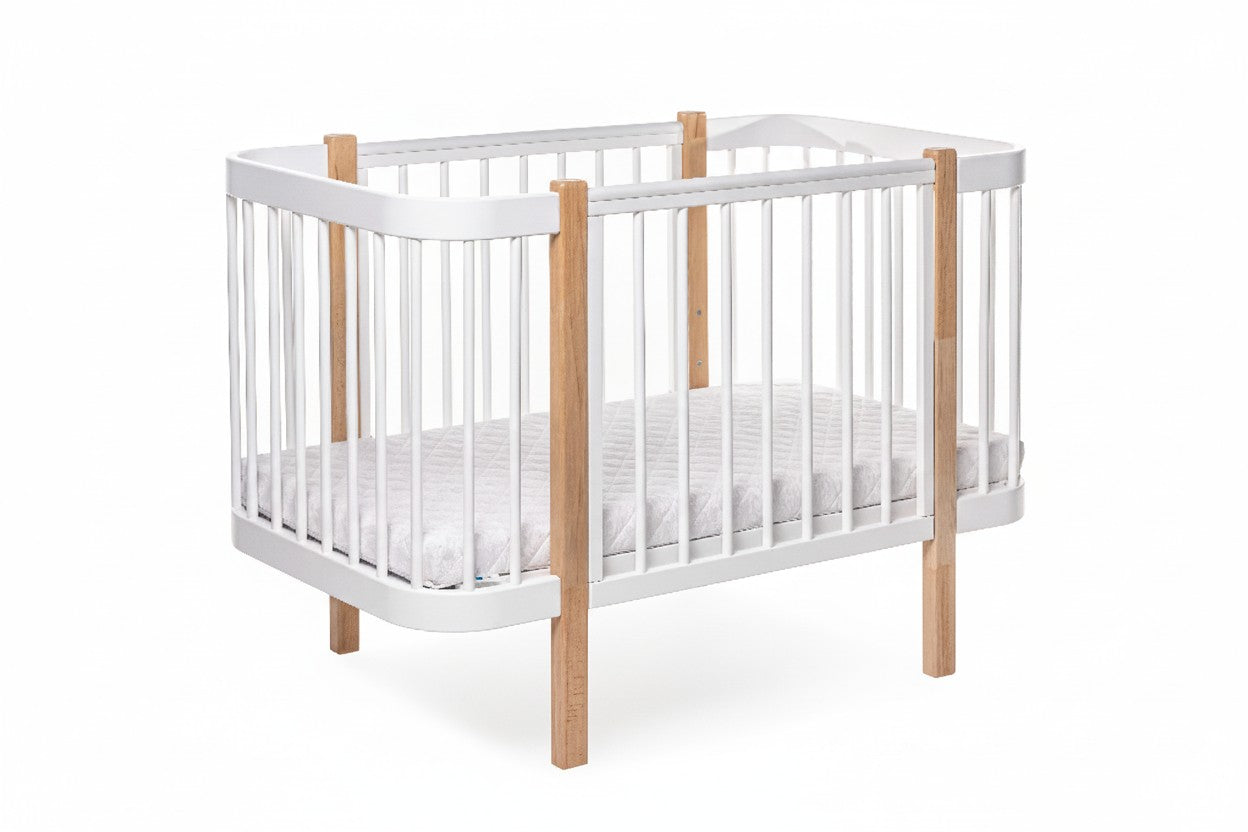 White ELIN baby crib with natural wood legs and adjustable slatted mattress base