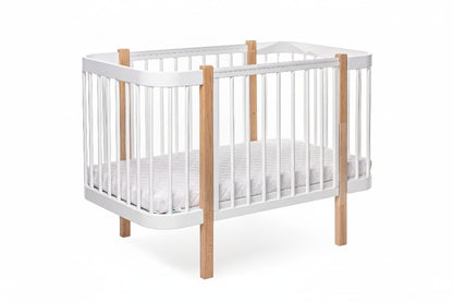 White ELIN baby crib with natural wood legs and adjustable slatted mattress base