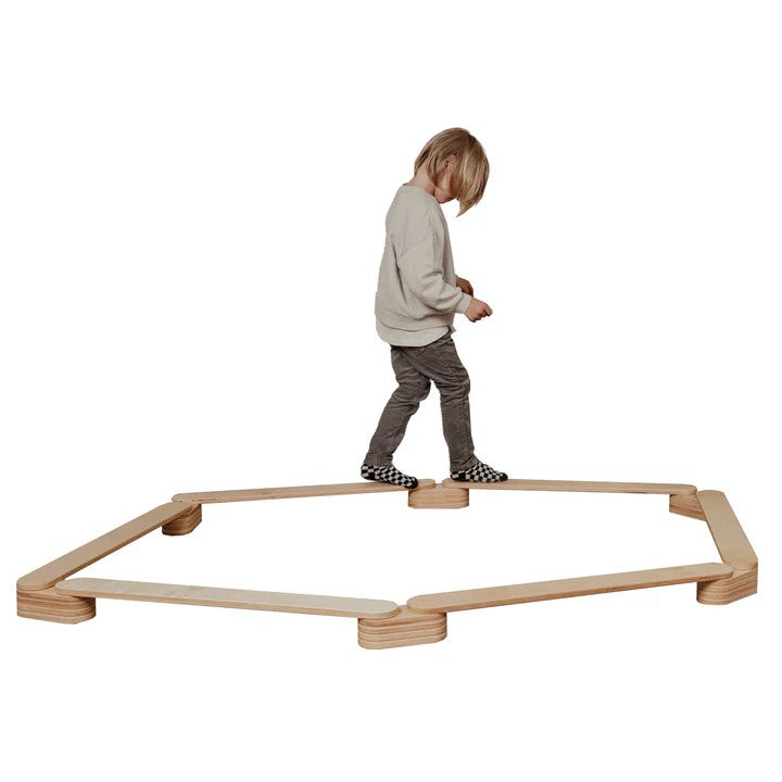 Child standing on wooden balance beam set showing the full assembled product