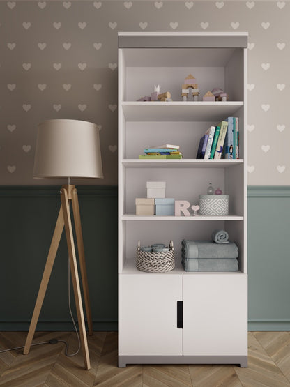 Kocot Kids Tomi bookshelf in white displaying books, toys, and storage baskets in a nursery room setting