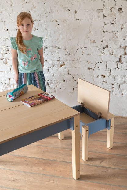 Child with toys at natural wood table featuring blue storage drawer