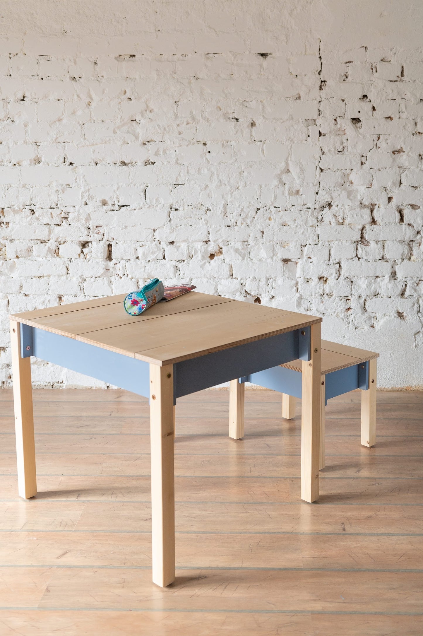 Wooden table and chair set with blue storage compartment and natural finish