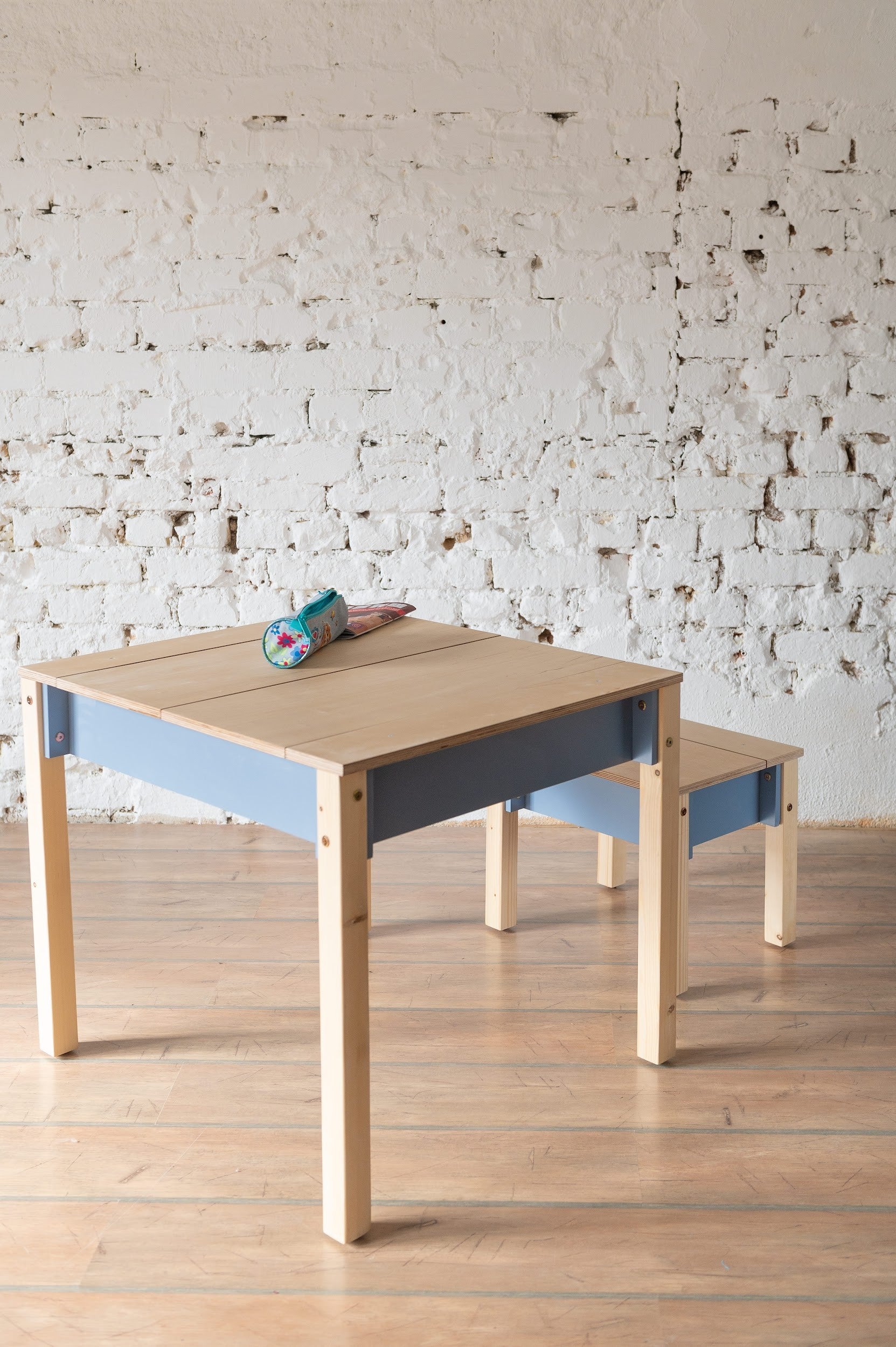 Wooden table and chair set with blue storage compartment and natural finish