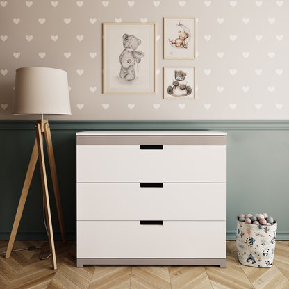 White Tomi chest of drawers with grey accents and black handles in nursery room setting