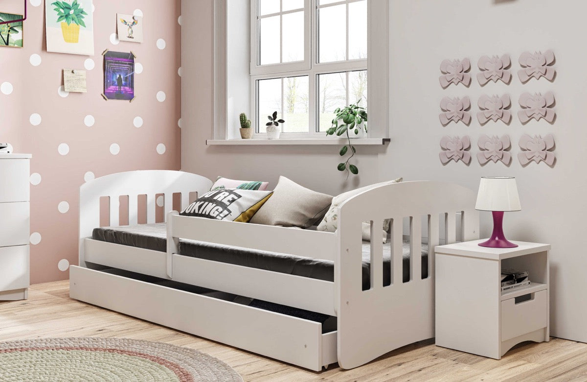White Kocot Kids Classic 1 children's bed with guardrail in pink bedroom with matching nightstand