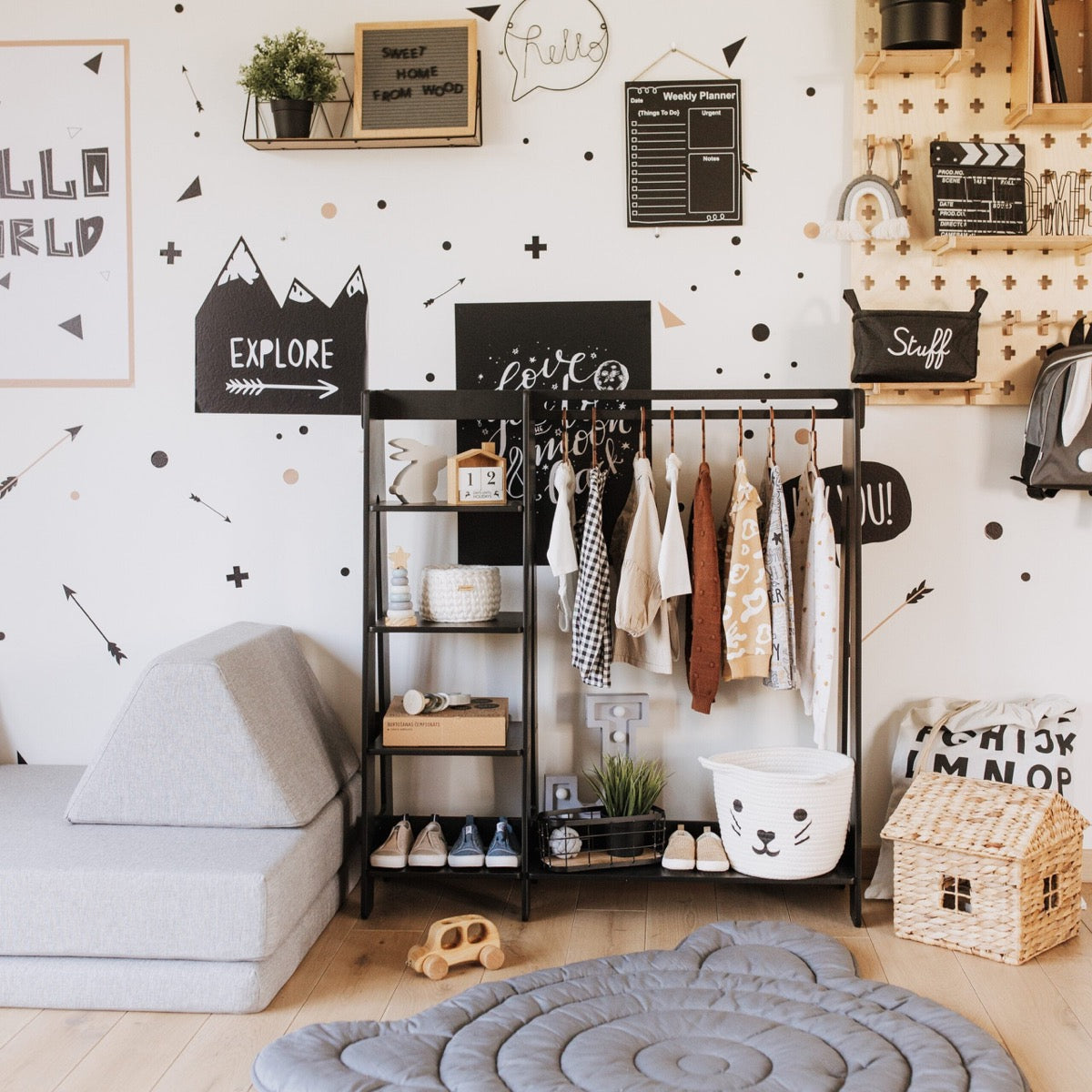 Black kids clothing rack with shelves styled in playroom with hanging clothes and storage