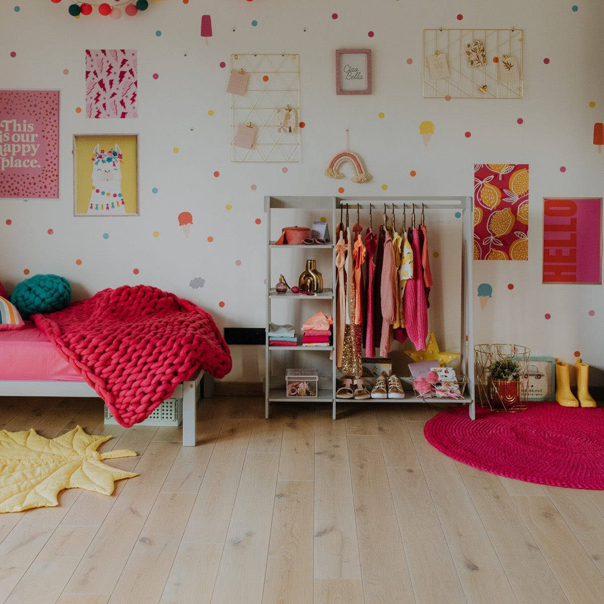 Montessori clothing rack with shelves in colorful kid's bedroom with hanging outfits