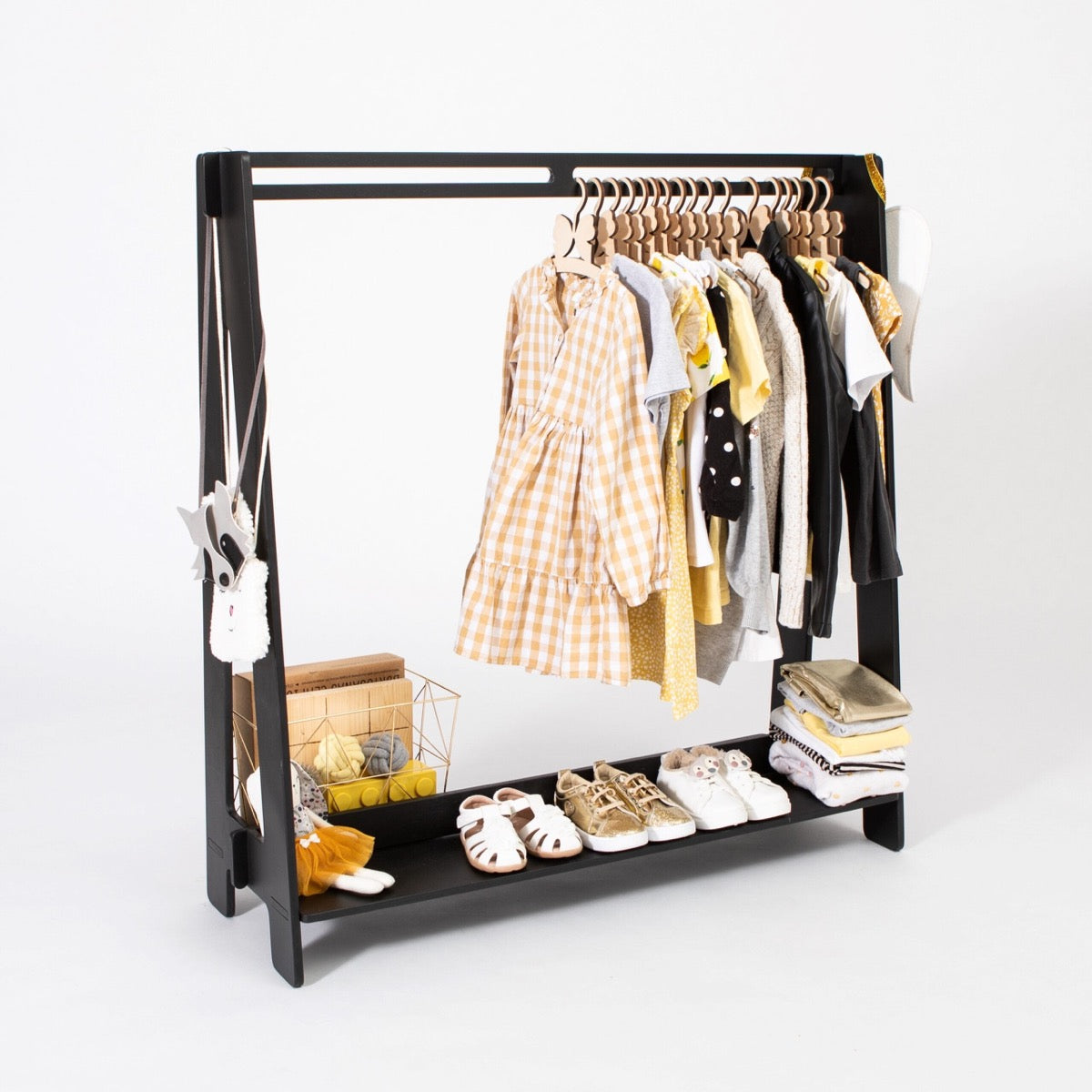 Black kids clothing rack with natural wood hangers holding mixed colored children's clothing