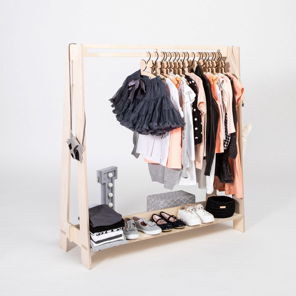 Natural wood kids dress-up rack filled with assorted children's clothing and footwear