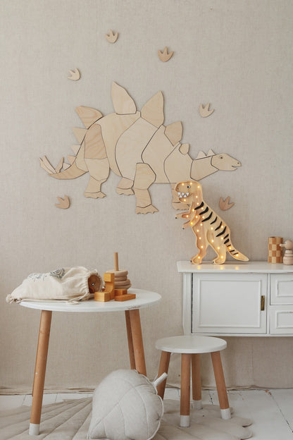 Close-up of natural wood stegosaurus wall puzzle with tan and brown dinosaur figurines
