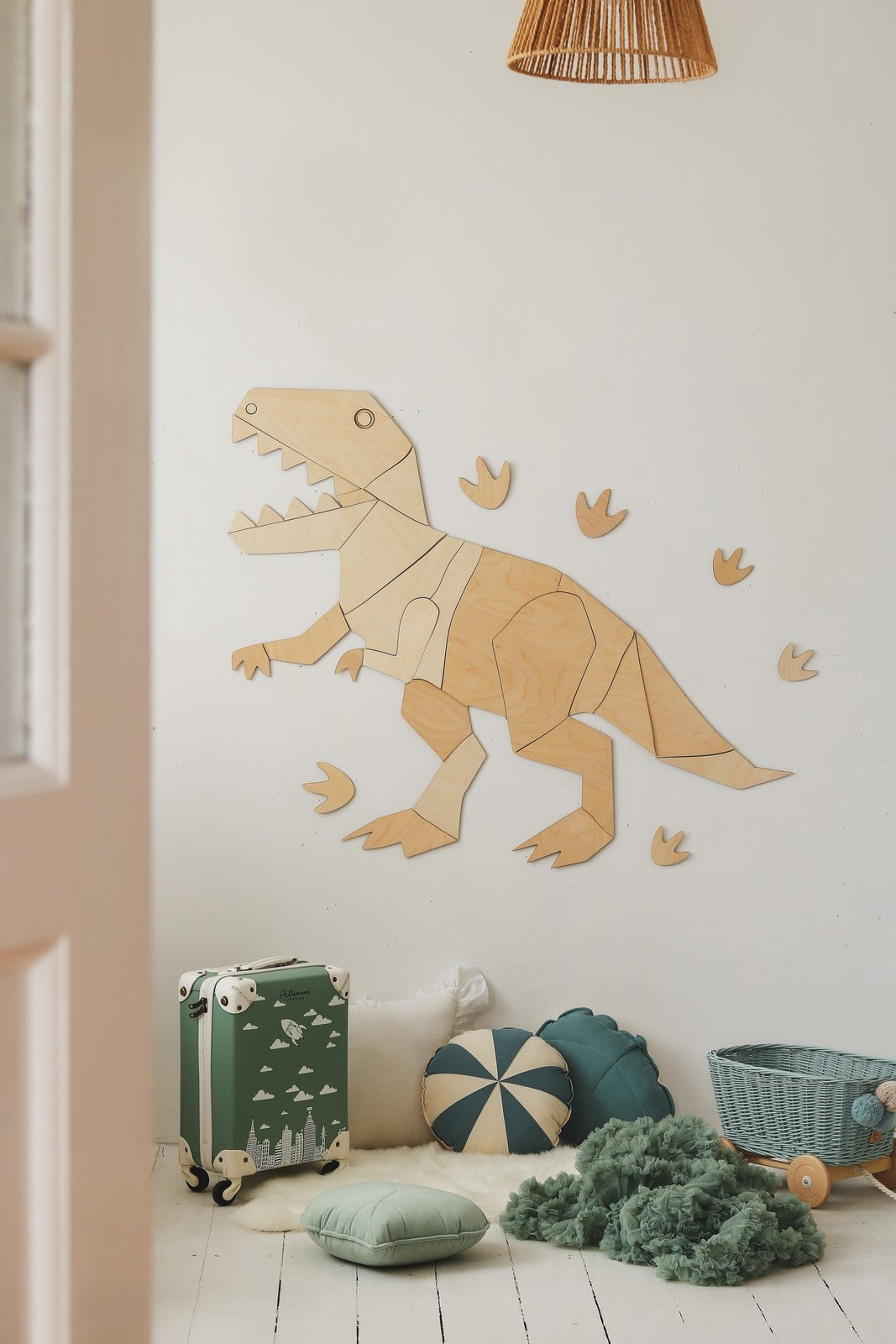 Wooden T-Rex wall decoration with footprints mounted on playroom wall above storage items