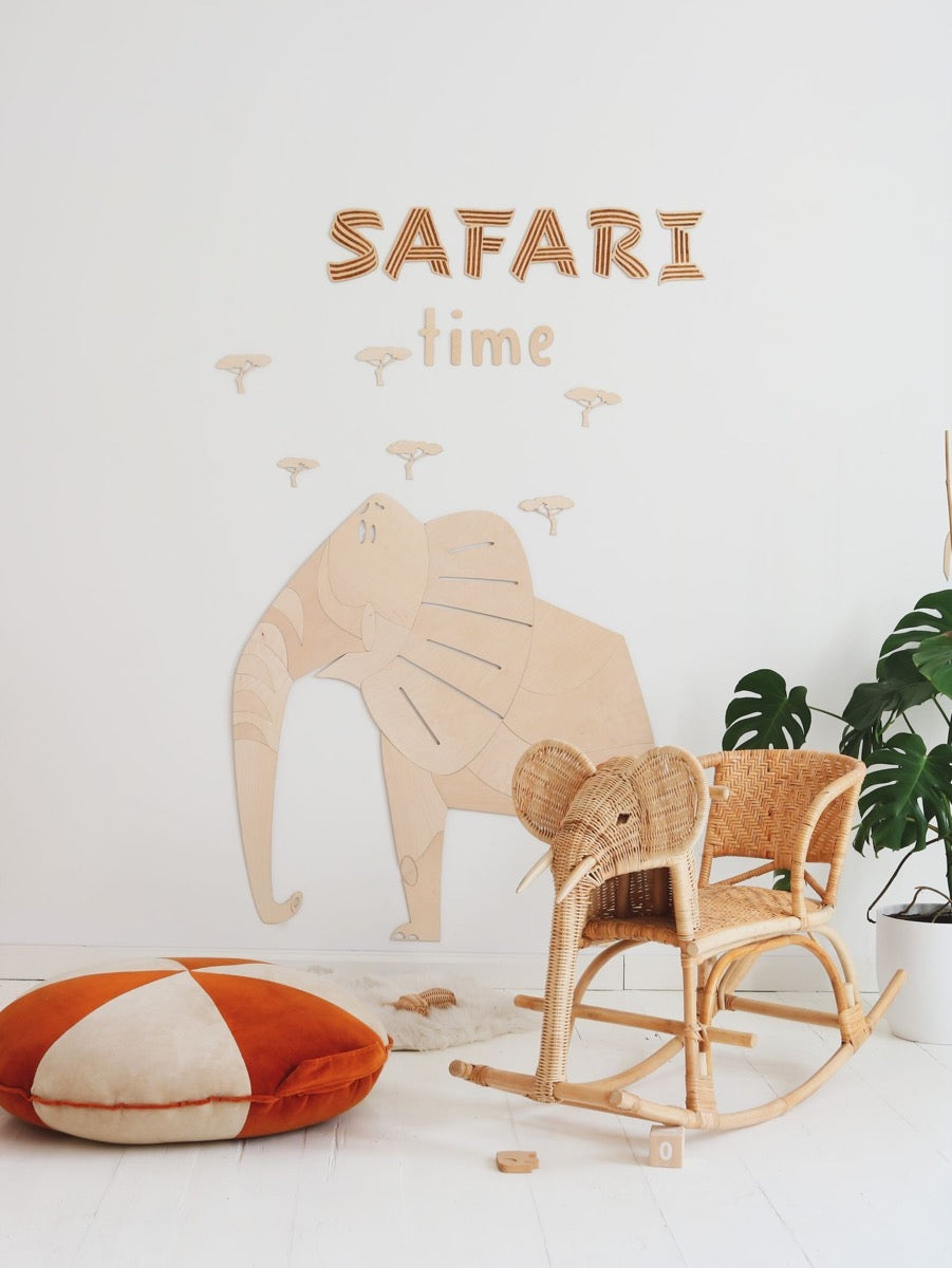 Safari-themed wooden elephant wall art with text and acacia trees above rocking chair