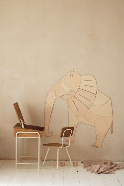 Wooden elephant wall decoration with modern furniture showing scale in playroom setting