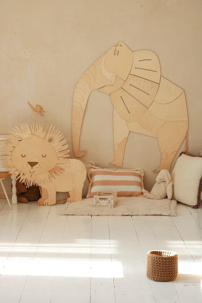 Wooden elephant and lion wall decorations styled with cushions and storage in bedroom