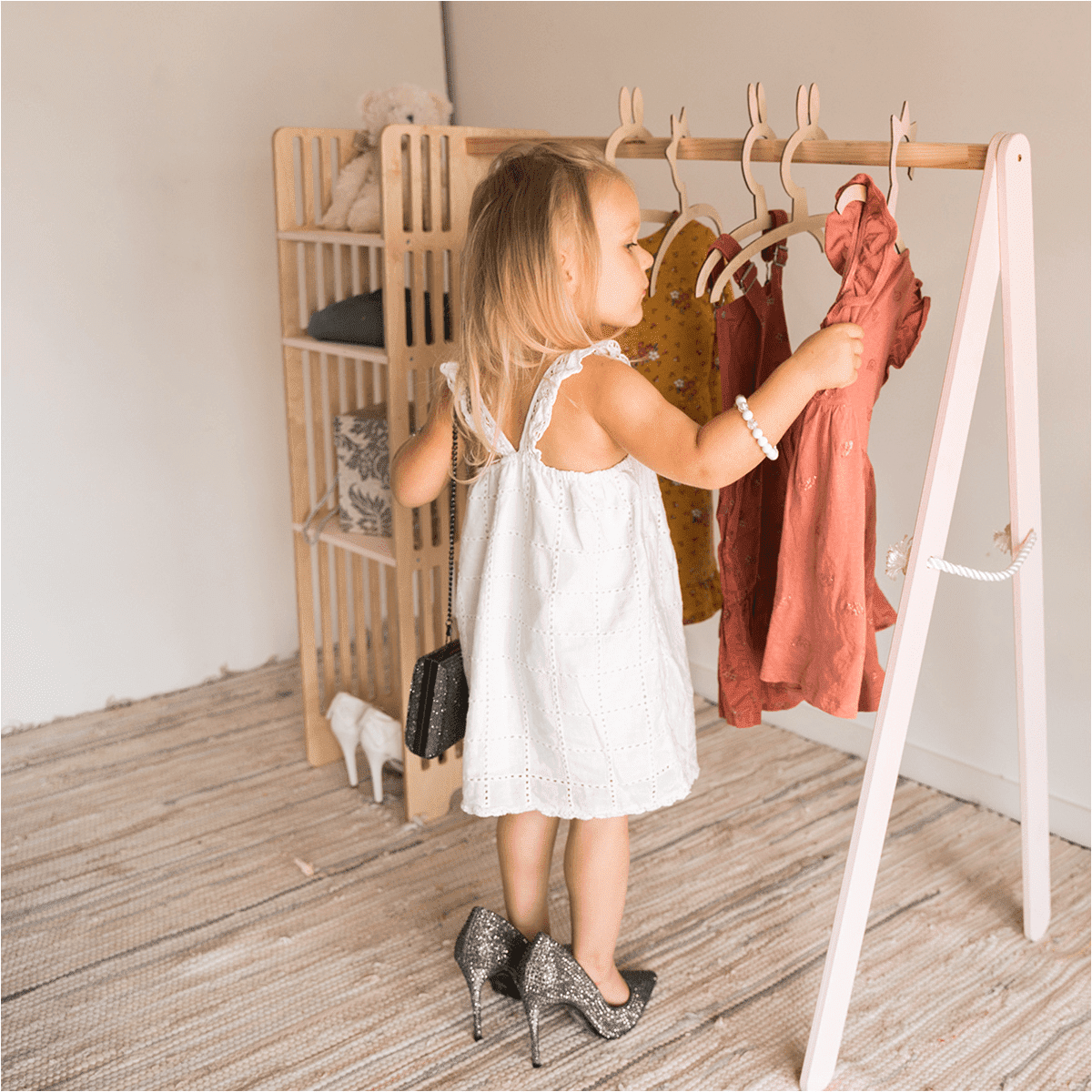 Young child accessing clothes on wooden wardrobe rack, showing child-friendly height and ease of use