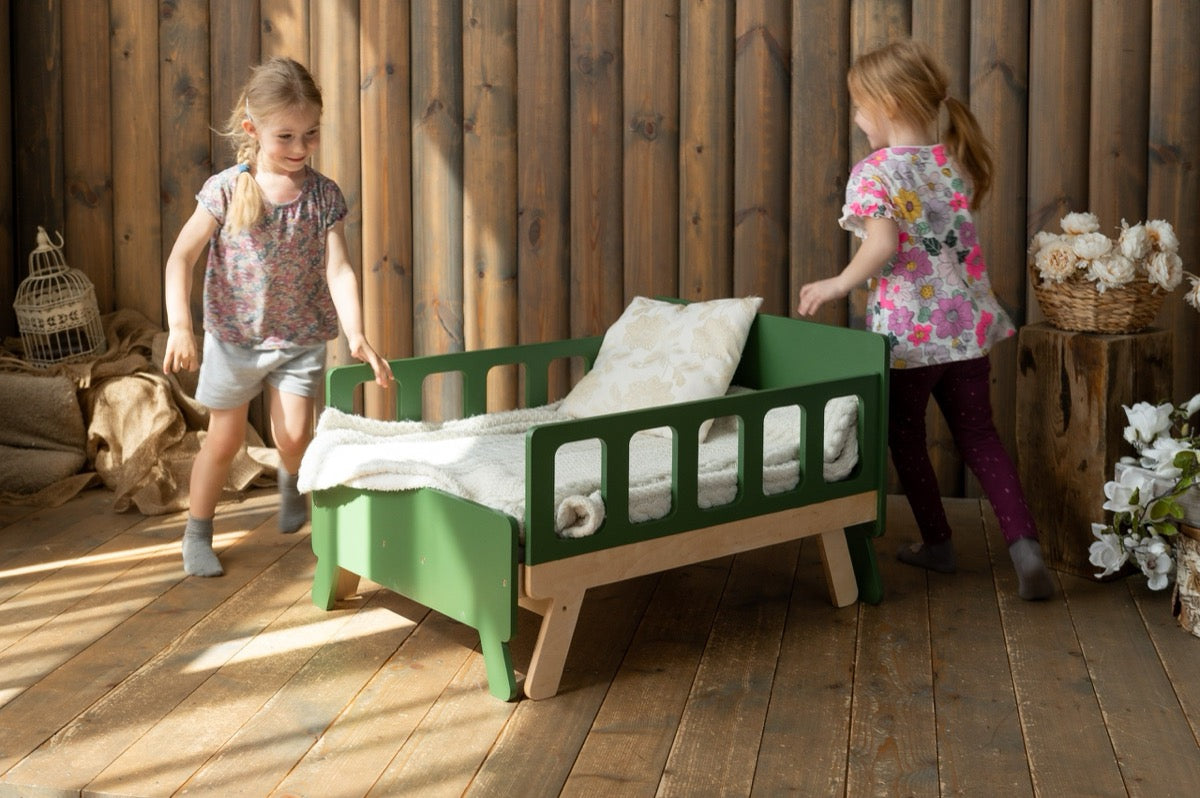 Two girls playing around green Family-scl growing bed – sturdy extendable kids bed for active children