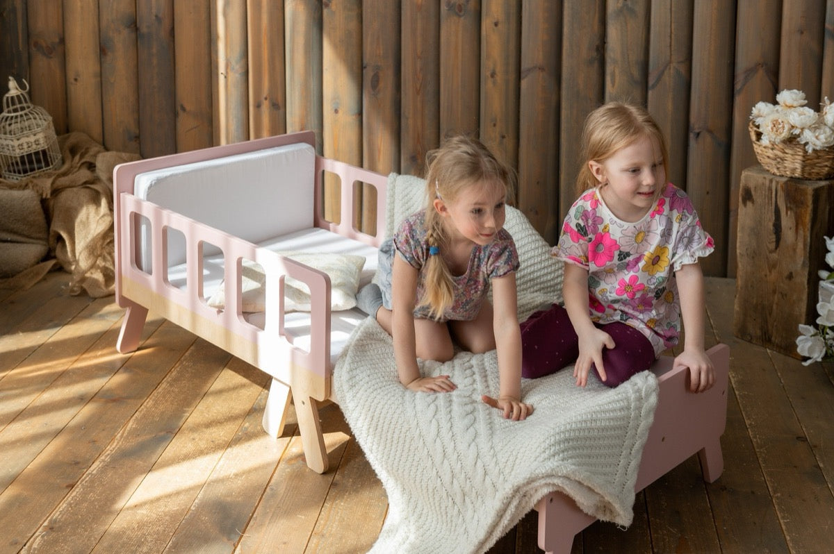 Two girls playing on pink Family-scl extendable kids bed – space-saving toddler bed for siblings