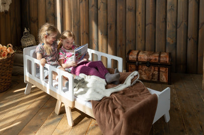 Two girls reading on white Family-scl growing bed – extendable children's bed for daily use and play