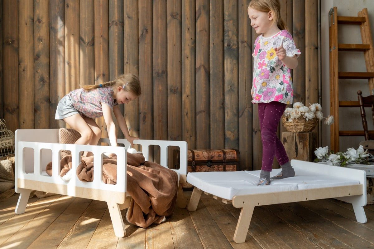 Girls playing on white Family-scl growing bed showing both sofa and extended bed configurations