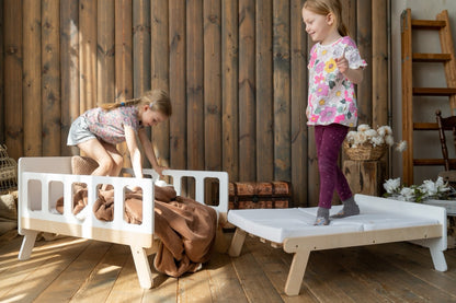 Girls playing on white Family-scl growing bed showing both sofa and extended bed configurations