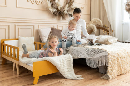 Girl on yellow Family-scl growing bed next to mother and baby – convertible kids bed fits any bedroom style