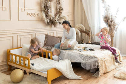 Family scene with yellow Family-scl growing bed – mother and children in boho-style kids bedroom